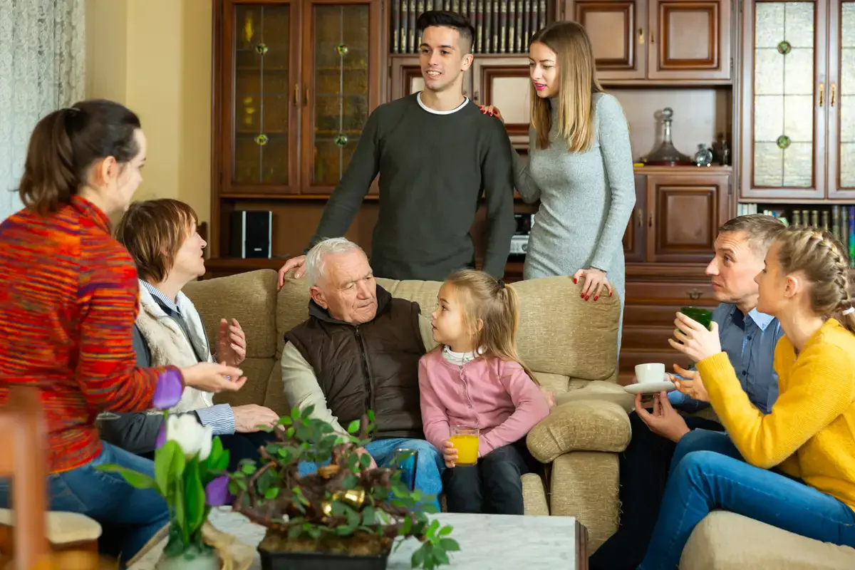 family-conflict-over-assisted-living-discussion-living-room Multi-generational family in a living room discussing care options—family conflict over assisted living.